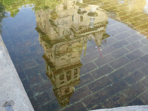 Reflection of the once minaret, now belfry, in a fountain in the Patio de los Naranjos