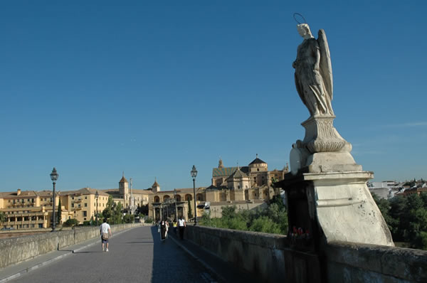 Archangel Raphael watches over Cordoba from the Roman Bridge - the faithful leave candles